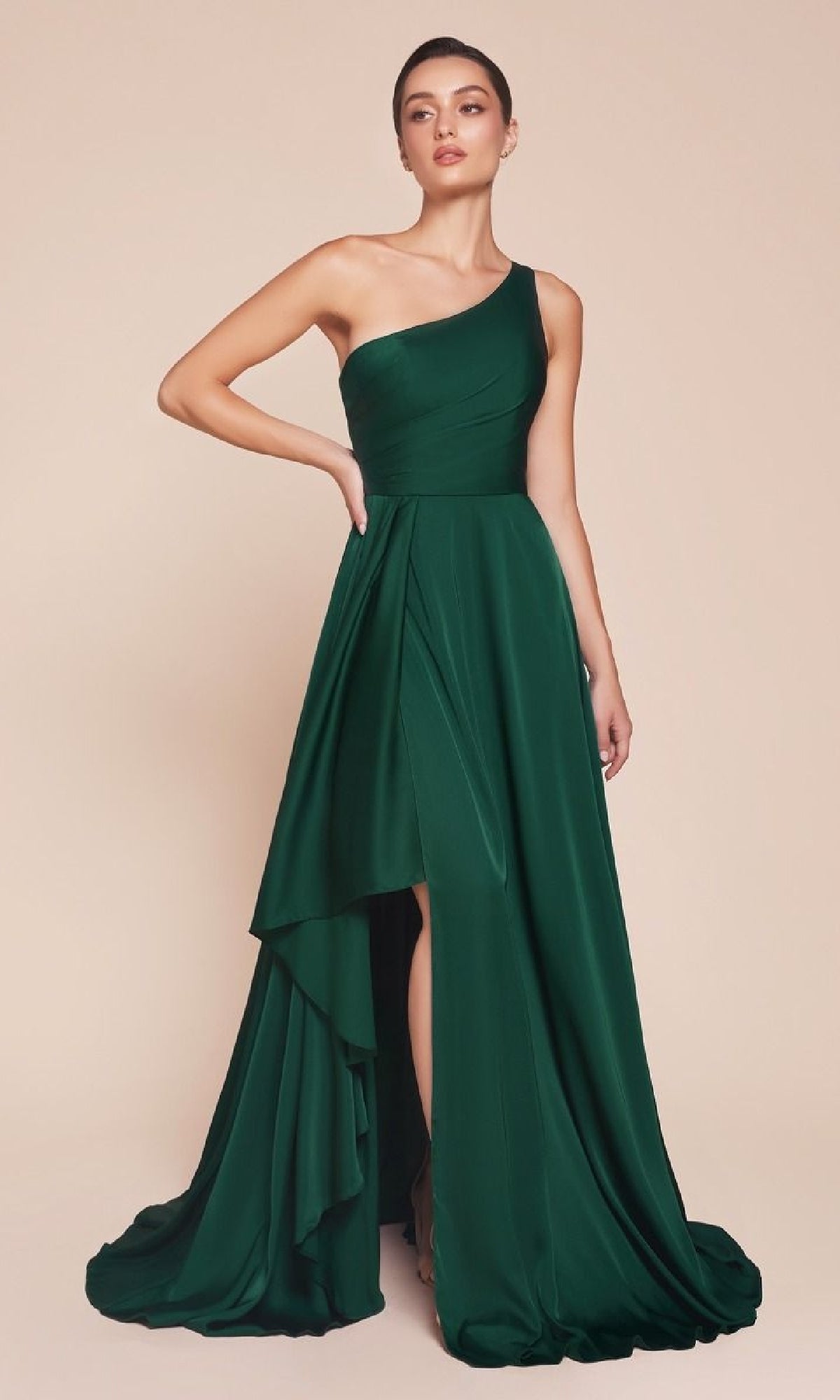 A woman wears the Ladivine 7450, a dark green, one-shoulder long A-line prom dress with a draped asymmetrical skirt and floor-length silhouette, styled elegantly against a plain beige background.